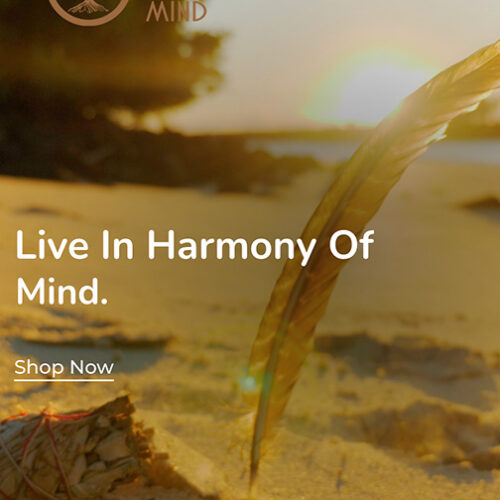 A beach scene with a feather sticking out of the sand at sunset. Text reads "Live In Harmony Of Mind" and "Shop Now on our Website." Sage Your Mind logo is in the top-left corner.